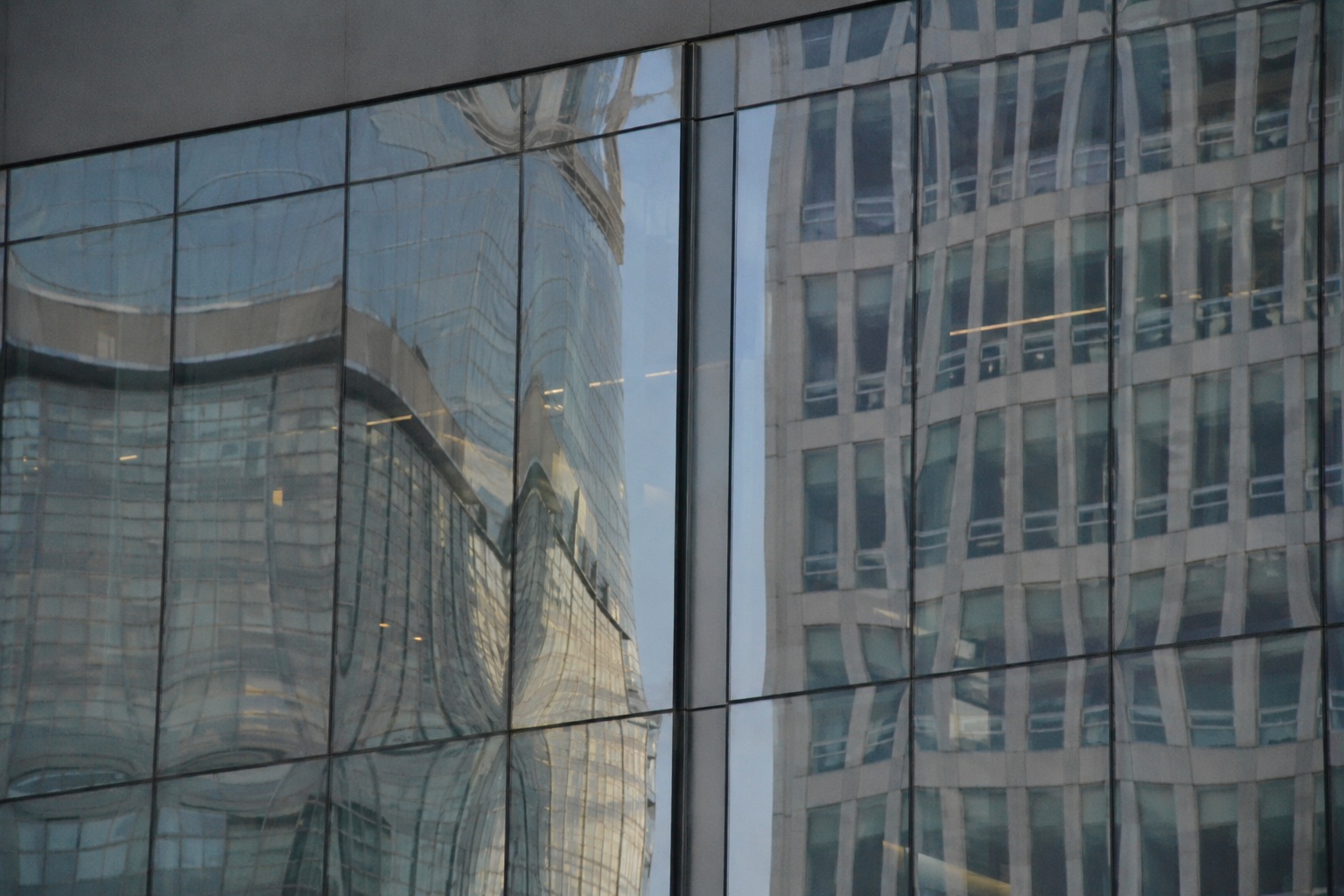 Reflected building facade showing wavy, distorted reflections caused by roller wave in tempered glass
